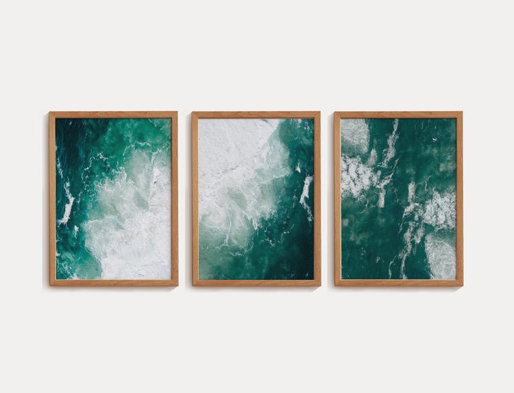 Trio de quadros de fotografia representando o mar. O mar possui uma coloração verde bem escura e ondas espumosas brancas.