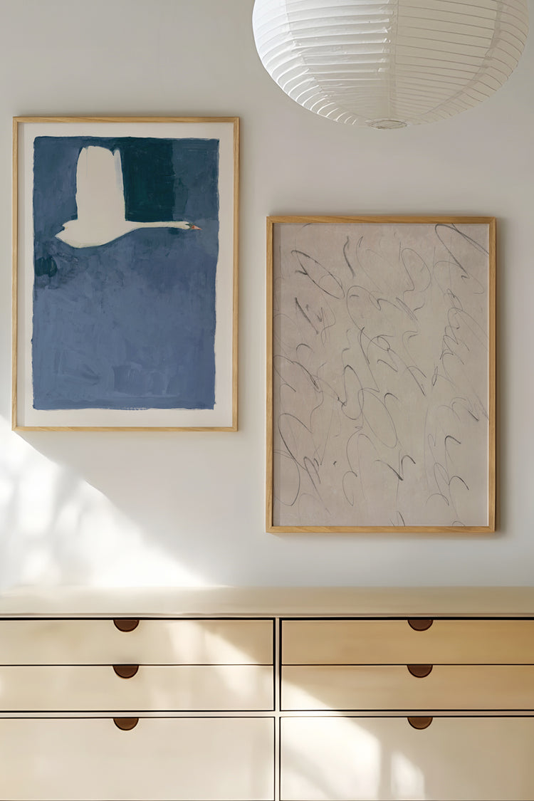 Decoração minimalista com quadros modernos sobre cômoda bege – arte contemporânea em azul e tons neutros, ideal para ambientes claros e sofisticados.