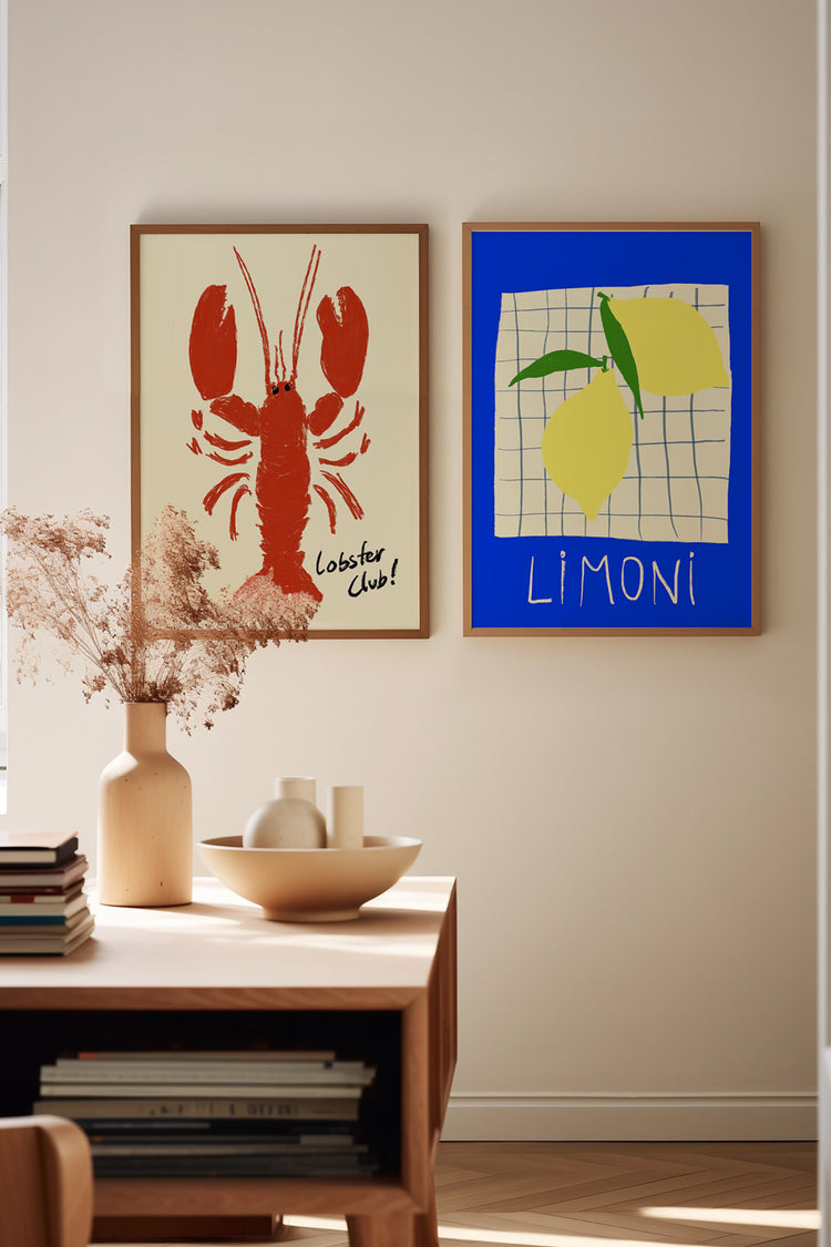 Parede com dois quadros ilustrativos de estilo playful: uma lagosta vermelha com texto “Lobster Club!” e limões amarelos sobre fundo azul com a palavra “Limoni”. Ambiente iluminado com móveis de madeira e decoração minimalista.