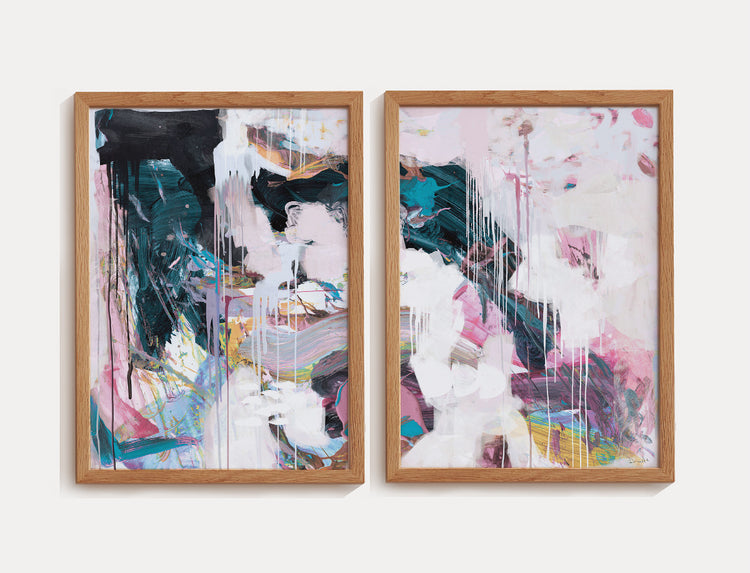 Par de quadros abstratos com pinceladas expressivas em tons de rosa, verde escuro, branco e toques de azul e amarelo, emoldurados em madeira clara.