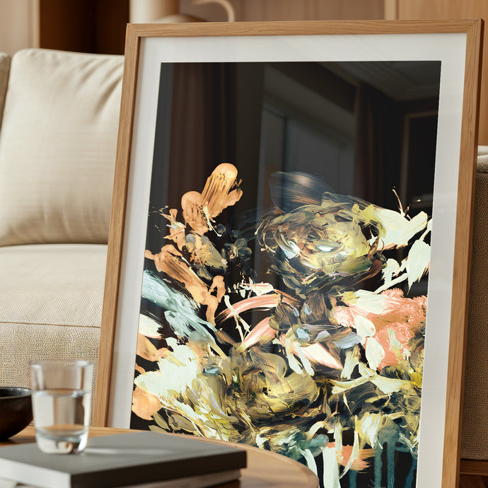 Quadro de moldura padrão com paspatur, abstrato com fundo escuro e flores estilizadas em pinceladas encostado em um sofá de linho.